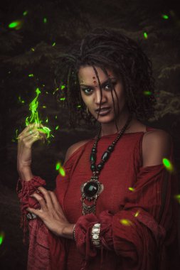 Kadın saç modeli dreadlocks ve kırmızı elbiseler ve elini gelen yeşil ateş ile