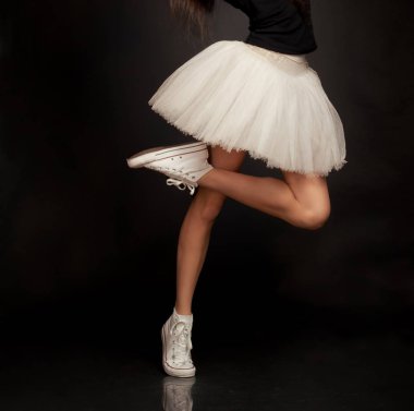 Balet studio arka planda tutu ve spor ayakkabı ayakkabı ile kadın bacakları