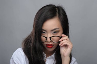 Beyaz bluz gözlüklü güzel genç Asyalı Kız portresi