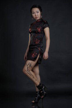 Asian woman with fake drawing tattoo on her leg clipart