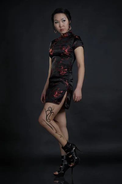 Femme asiatique avec faux tatouage de dessin sur sa jambe — Photo