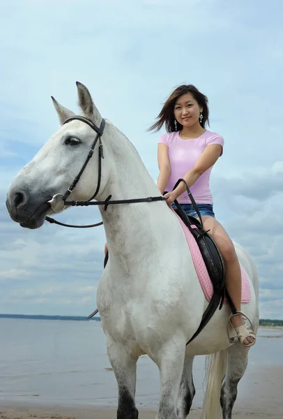 Young asian woman riding white horse on the beach — Stock Photo, Image