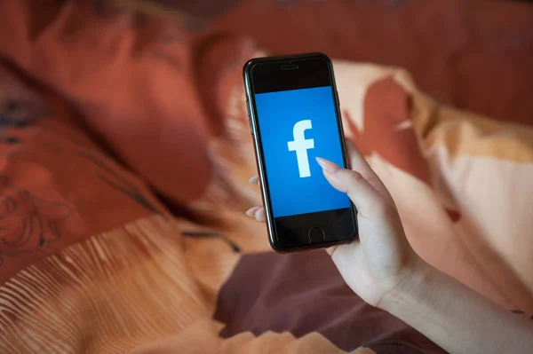 Tangan wanita dengan manikur memegang ponsel dengan Facebook — Stok Foto