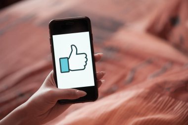 Facebook Like ile manikür tutan cep telefonu ile Kadın el