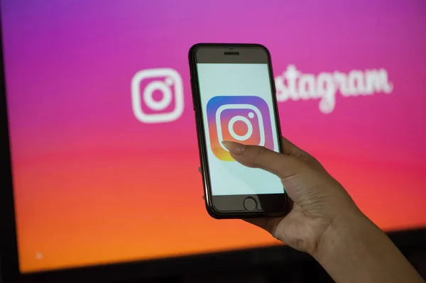 Tangan wanita memegang ponsel dengan halaman awal Instagram — Stok Foto