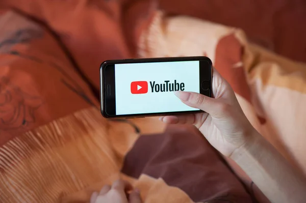 Tangan wanita dengan manikur memegang ponsel dengan Youtube — Stok Foto