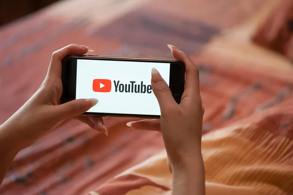 Tangan wanita dengan manikur memegang ponsel dengan Youtube — Stok Foto