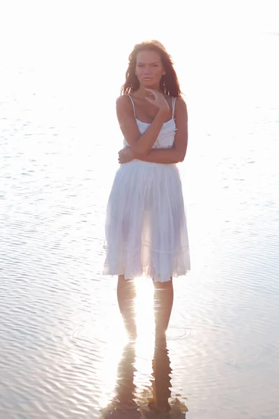Mladá štíhlá žena oblečená v bílých slunečních šatech — Stock fotografie