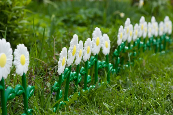 Malý bílý plastický plot na zelené trávě — Stock fotografie