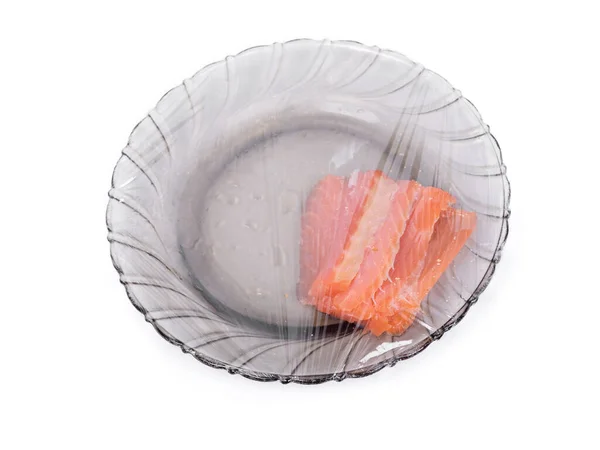 Stück Fisch Auf Teller Unter Frischhaltefolie Isoliert Über Weißem Hintergrund — Stockfoto