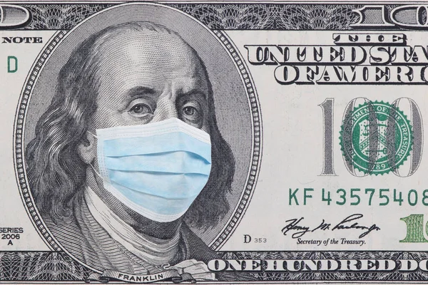 Yüz dolarlık banknot, beyaz arka planda yüz maskesi var. Amerikan nakit parası. Finansal kriz ve koronavirüs salgını konsepti. ABD 'de COVID-19 Coronavirüs.