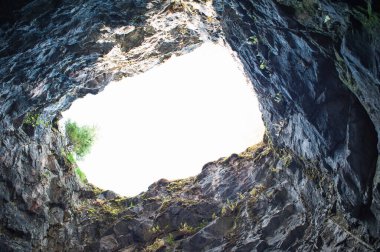 İçerideki kayalık mağarada aşağıdan yukarıya doğru bir delik.