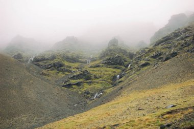 Bir sis küçük şelaleler ile dağlarda İzlanda
