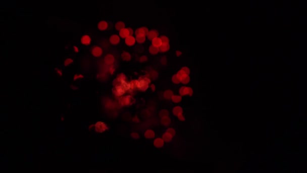 烟花背景具有散景和光学黑洞效应。红色和金色圆圈 — 图库视频影像