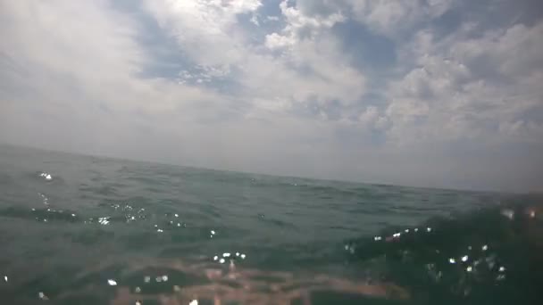 Молодой человек плавает в морской воде POV — стоковое видео