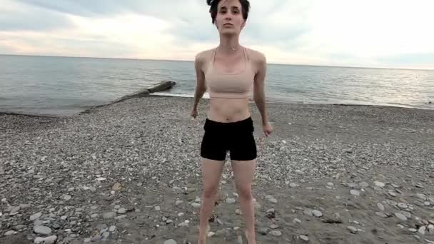 Jeune belle femme faisant de l'exercice au bord de la mer. Mode de vie sain. Concept de fitness . — Video