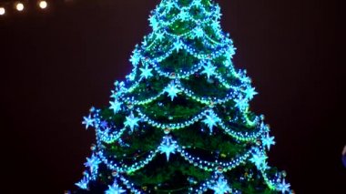 Şehir Noel ağacı çok renkli çelenkler, toplar ve yıldızlarla süslenmiş