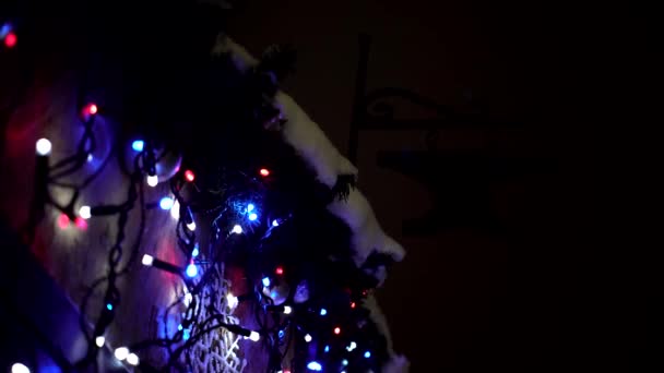 Luces intermitentes borrosas blancas, azules y rojas de guirnaldas en el puesto del mercado de Navidad con veleta meteorológica forja — Vídeos de Stock