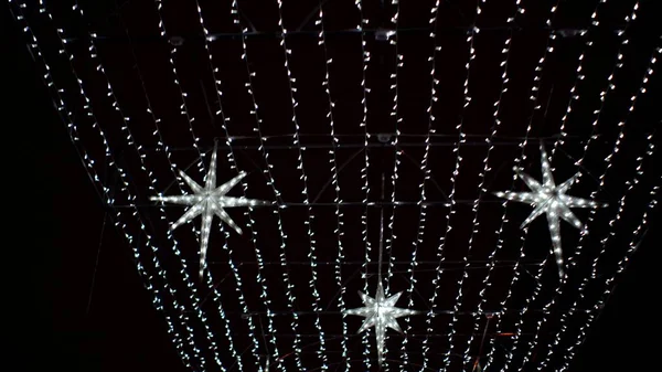 Guirlandas brancas com estrelas movimento da câmera ao longo da vista inferior beco do parque — Fotografia de Stock