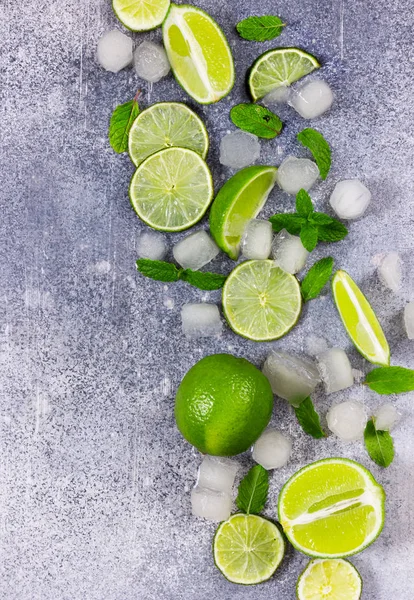 Frischer Kalk, Minze und Eis auf grauem Hintergrund. — Stockfoto