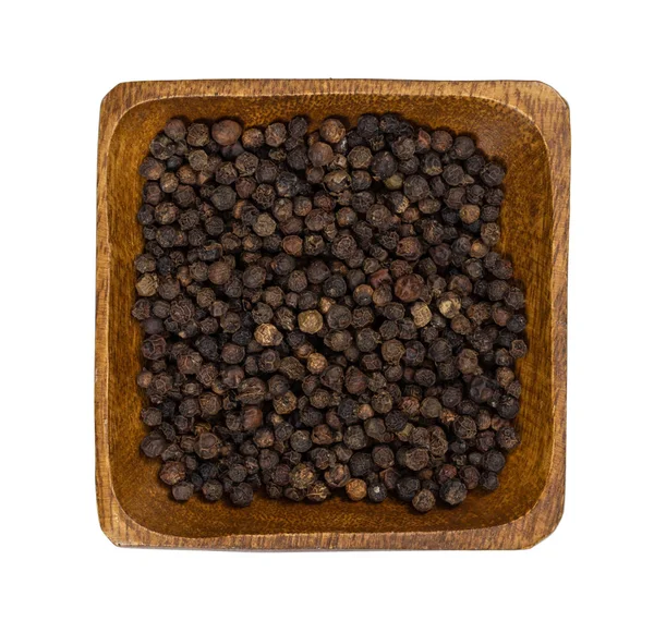 Black pepper peas in wooden bowl isolated on white — Stock Photo, Image