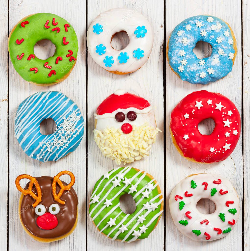 Set of Christmas donuts on light wooden background.  