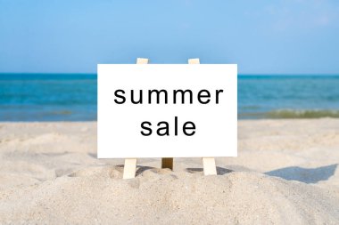 Güneşli kumsalda tahta beyaz tahta..