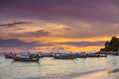 Birçok uzun tekneler Lipe plaj tayland inanılmaz güzel yaz günbatımı görünümü ile denizde yüzen.