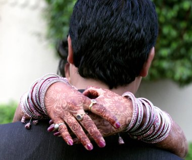 Pakistan ve Hindistan damat sarılma veya eller ve yüzük, bilezik ve Mehndi sanat düğün gelin gösterilen tutan gelin