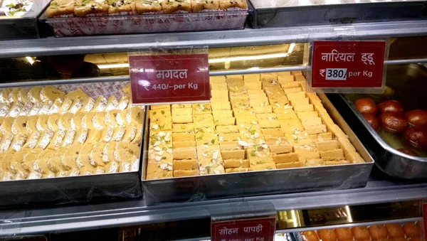 Sobremesas indianas doces loja com lista de preços na pequena cidade indiana — Fotografia de Stock