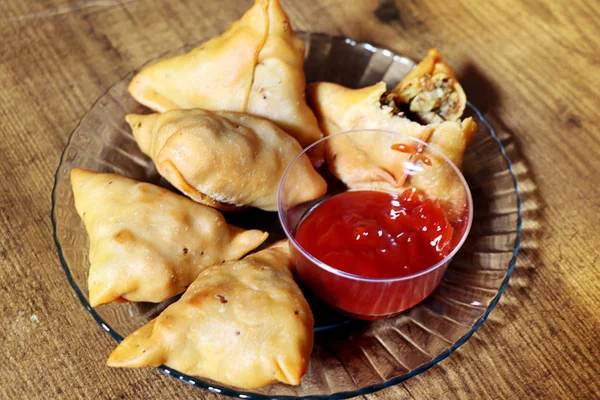 Veg Samosa es un bocadillo crujiente y picante en forma de triángulo indio que tiene una capa exterior crujiente de maida y relleno de puré de papa, guisantes y especias. . —  Fotos de Stock