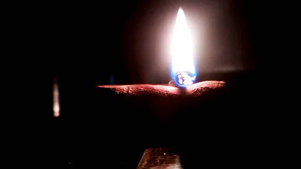 Imagem de perto de um diya de barro iluminado ou lâmpada no chão em Diwali - um festival hindu indiano de luzes isoladas no fundo preto . — Fotografia de Stock