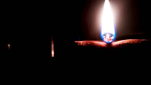 Image rapprochée d'un diya d'argile allumé ou d'une lampe sur le sol de Diwali - un festival hindou indien de lumières isolées sur fond noir . — Photo