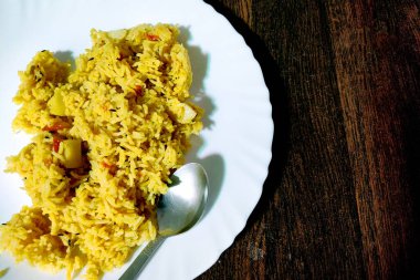 Basmati pilavı, bezelye, patates, domates ve hafif baharatlarla yapılmış taze pişmiş Hint sebze pulaosunun yakın çekimi.