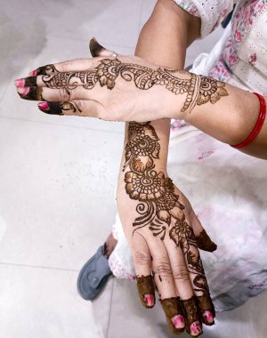 Kına dövmesiyle süslenmiş bir insan eli resmi, Hint düğün töreninde Mehendi konisi süslenmiş.