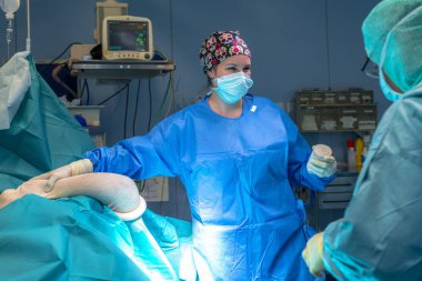 Hastanın kol yanına bandaj giyecek cerrah bekliyor tutan hemşire. Sen-ebilmek görmek ekranın arkasında.