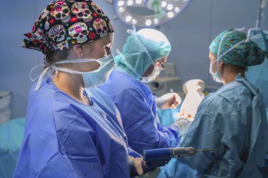 Cerrah, cerrahi asistanı ve ameliyat odasında çalışan hemşire cerrahi malzeme görebilirsiniz. Onlar işletim Oda ışıkla aydınlatılmış.