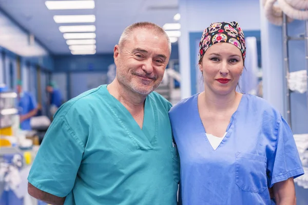 Erkek ve kadın cerrahlar portresi. Gülümsüyor ve ciddi bir kız. O renkli bir cerrahi şapkası giydi