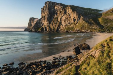 Lofoten, Norveç'te bir plajda dağın arkasında gün batımı.