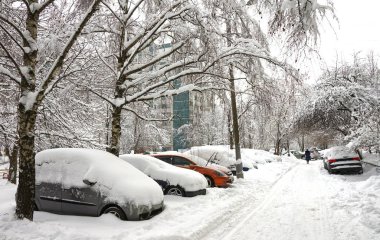 Kar yağışı, kar tabakası altında arabalara. Kış kentsel sahne.