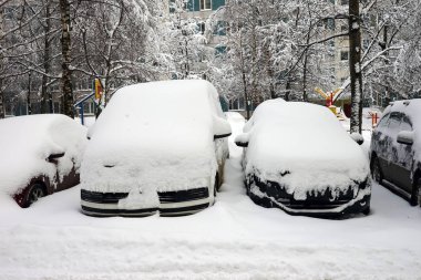 Kar yağışı, kar tabakası altında arabalara. Kış kentsel sahne.