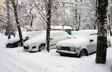 Kar yağışı, kar tabakası altında arabalara. Kış kentsel sahne.