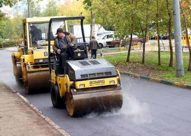Moskova, Rusya - Mayıs 2011: Kompaktörler asfalt, yeni bir yoldan Buhar. Moskova'da ortak alanlarda yenileme programı.