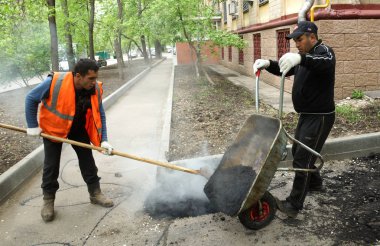 Moskova, Rusya - Mayıs 2011: Boşaltma asfalt gelen bir el arabası. Moskova'da ortak alanlarda yenileme programı.