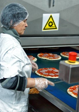 Moskova, Rusya - Ocak 2012: Bir kadın ile pizza konveyör. Pastane Moskova'da fabrika.