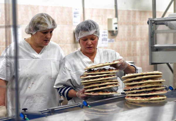 モスクワ ロシア連邦 2012 女性コンベヤーに半製品のピザ モスクワのベーカリー製品の工場 — ストック写真