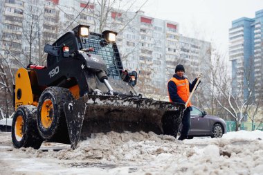 Moskova, Rusya - Ocak, 2015: Mini buldozer ve işçi, kar kaldırma. Şehrin sokaklarında kışın Moskova'da temizlik..