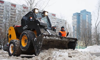 Moskova, Rusya - Ocak, 2015: Mini buldozer ve işçi, kar kaldırma. Şehrin sokaklarında kışın Moskova'da temizlik..