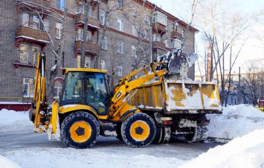 Moskova, Rusya - Ocak, 2015: Buldozer kar bir damperli kamyon yükler. Şehrin sokaklarında kışın Moskova'da temizlik..