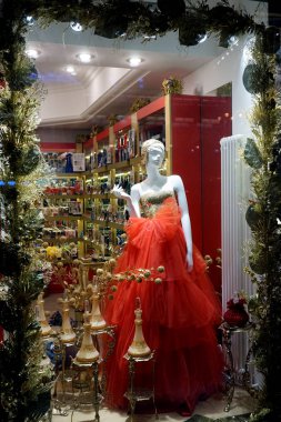 Moskova, Rusya - Kasım 2012: Bir giyim mağazasında Storefronts ile manken bir kadının bir kırmızı elbise. Kış Noel dekorasyonu, gece görünümü.